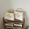 Bolso de mano de nicho retro europeo y americano 2026 nuevo, bolso tipo Kelly para mujer, bolso versátil de color liso simple para hombro y cruzado