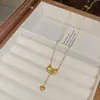 Versión coreana del nuevo y versátil exquisito collar de acero de titanio con lazo para mujer, lujo ligero, alto sentido, borla, amor, cadena para clavícula, venta al por mayor