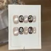 Um par de pontas de unha Gu [Jasmim Branco Dourado] cor marrom escuro Maillard e dourado estilo gatinho com delicados detalhes em rosa e dourado, feito à mão