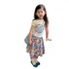 Conjunto Súper Estiloso de Niña Estilo Coreano Verano 2026 Nuevo Modelo, Moda de Top con Estampado de Manga Corta y Falda Floral de Moda para Niñas Pequeñas