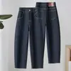 Jeans feminino azul escuro de cintura alta, corte reto (estilo cenoura), modelagem solta, com barra dobrada, comprimento cropped e efeito emagrecedor, modelo 2026
