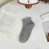 Calcetines para hombre 25 años simples absorbentes de sudor transpirables estirables color liso calcetines para mujer tobilleros primavera, verano y otoño calcetines de algodón de tubo corto venta al por mayor