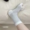 26 Novas meias listradas de cano médio estilo coreano com dois dedos, apresentando um visual descontraído e casual, com base branca e listras pretas, sem tamanho específico, feitas de algodão