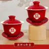 Um conjunto de xícaras de chá de casamento, incluindo um par de tigelas de chá e pauzinhos vermelhos e festivos, perfeito para servir chá durante a cerimônia de casamento.