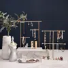 Estante minimalista de oro para guardar joyas con múltiples niveles de ganchos para colgar collares largos y cortos, aretes y anillos, con una base
