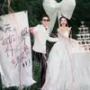 2025 fotografía de boda ubicación viaje accesorios mano plato tarjeta de letra lazo blanco decoración de fondo