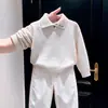 Conjunto de dos piezas para niño estilo coreano otoño e invierno 2026: suéter de punto beige con cuello, elegante, y pantalones blancos de pierna ancha para niños
