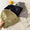 Pantalones largos para niños 2026 nuevo producto de verano, pantalones unisex de color liso con cordón y letras, pantalones curvos versátiles para niños pequeños
