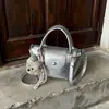 Diseño moderno, simple, gran capacidad, texturizado, estilo coreano, color liso, nuevo modelo 2026, bolso bandolera con colgante de bola de masa para mujer