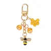 Bestseller transfronterizo: Llavero de aleación con recubrimiento de esmalte con diseño de abeja y panal incrustado con diamantes, llavero de dibujos animados, funda para auriculares, accesorio para bolso