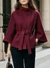 Roupas femininas transfronteiriças europeias e americanas de 2026: gola alta, fechamento diagonal por botões, mangas amplas, cintura marcada com cinto e elegante casaco de lã para o trajeto