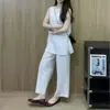 Impresionante atuendo casual minimalista de verano estilo coreano 2026: conjunto de top sin mangas negro en capas con pantalones de pierna ancha