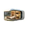 Casa cápsula espacial inteligente moderna e minimalista com iluminação completa e grandes janelas panorâmicas do chão ao teto para férias no campo, cabana pré-fabricada