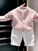 Ropa infantil coreana 2026 colección otoño/invierno nueva: conjunto de suéter rosa de punto trenzado, cárdigan de punto y pantalones casuales blancos para niños y niñas