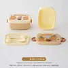 Lancheira dobrável com divisórias e design elegante, com várias opções de compartimentos, ideal para crianças e estudantes. Acompanha garfo e colher.