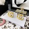 Precio de fábrica al por mayor comercio exterior joyería de cobre elegante retro hacer viejo pendientes Doble G simples estilo INS atmosféricos pendientes de botón con letra para mujer