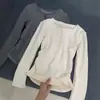 Camiseta de manga comprida com botão de nicho de designer para mulheres, roupa íntima para primavera e outono, blusa base curta, estilo hot girl slim fit, mostra a magreza, top