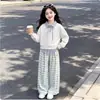 Nueva colección chic de estilo coreano para niñas de Primavera y Otoño: un conjunto de dos piezas que presenta un top con cuello y apariencia de capas y pantalones casuales a cuadros, perfecto para un estilo versátil