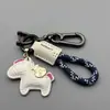 Llavero de dibujos animados "Hazte rico al instante" Llavero creativo para llaves de coche Cuerda tejida a mano de cuero Colgante para mochila Regalo