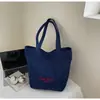 Bolsa de mano tipo tote simple de estilo coreano al por mayor para mujer 2025 Verano Nuevo Gran Capacidad Hombro Único Lona Versátil Bolso de Axila