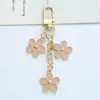Nuevo llavero colgante de flor colorida ins, creativo, aleación DIY, flor pequeña de doble cara, decoración para funda de auriculares, bolso