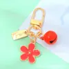 Llavero de Metal Pequeña Flor Estilo Ins con Goteo de Aceite Doble Cara con Etiqueta Pequeña y Cascabel Colgante para Bolsa de Auriculares de Niñas