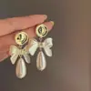 Brincos de Pérola com Laço Dourado para Mulheres 2025 Novo Luxo Acessível Design de Nicho Brincos de Alta Qualidade Brincos Elegantes