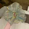 Vibrações de primavera e verão com um elástico de cabelo com miçangas de fio verde menta cintilante de sereia para um penteado de rabo de cavalo baixo