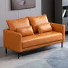 Gato rasguñando sofá de cuero sala de estar apartamento pequeño simple doble tres personas nórdico simple alquiler tienda de ropa apartamento naranja