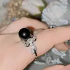 Anillo Versa de borla de lazo asimétrico con perla negra, anillo Tahidi de cuentas de concha marina barroca con circón