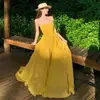 Vestido sexy amarillo de gasa estilo francés con espalda descubierta, tirantes sueltos y volantes irregulares, perfecto para vacaciones y playa