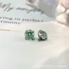 Liga de titânio F136 com cravação em garra de fundo redondo e detalhes verde menta, brincos de tarraxa Paraíba, rosca interna de titânio G23, argolas de lábio com zircônia cúbica