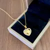 Elegante conjunto de collar y pendientes de corazón totalmente de diamantes, cadena para la clavícula de acero de titanio moderna y versátil, joyería de alta calidad de moda al por mayor
