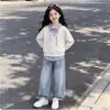 Conjunto de primavera/otoño moderno y minimalista para niñas: un nuevo diseño de estilo coreano con un top de patchwork y pantalones vaqueros con un lazo, un conjunto versátil de dos piezas