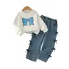 Estilo europeo y americano: un atuendo de niña dulce y delicado que presenta un top blanco, suave y de manga larga con un diseño de lazo completo en el lateral, combinado con pantalones de mezclilla - un conjunto de dos piezas