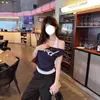 Camiseta de Manga Corta con Hombro Descubierto Inclinado de Chica Caliente Americana para Mujer Verano Diseño de Chica Caliente Aspecto Adelgazante Parte Superior Fruncida en la Cintura