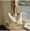 Bolsa de lona bordada de baja saturación, simple y elegante para trabajadoras de oficina, adecuada para el uso diario como bandolera o bolsa de mano.