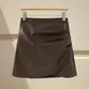 Falda irregular de piel sintética marrón para mujer, estilo otoño e invierno, combinada con botas, talla grande, estilo Miu, minifalda de línea A ajustada a la cadera