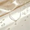 Colar de pérolas de camada dupla estilo europeu e americano transfronteiriço para mulheres, apresentando um pingente de pérola sintética em formato de gota moderno e único e uma corrente para a clavícula