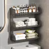 Baño de estilo abierto con un inodoro, un soporte para pañuelos de papel y toallitas húmedas encima del inodoro, y un estante de pared para toallas perfumadas