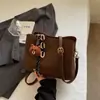Bolso cruzado de un solo hombro texturizado 2025 Invierno Nueva moda Bolso tipo cubo moderno Estilo nicho Bolso casual elegante para mujer