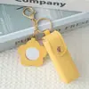Mini llavero de lipstick portátil, bolsa redonda de cuero con espejo de maquillaje, accesorio para niñas, colgante de bolsa de espejo de maquillaje portátil
