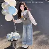 Conjunto simples e estiloso para meninas apresentando um colete fofo de urso, uma blusa doce de gola boneca estilo coreano e calças jeans versáteis com estampa de estrelas.