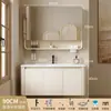 Tocador de baño engrosado y ahorrador de espacio con diseño en color crema, que cuenta con un lavabo redondeado, lavabo cerámico integrado y un lavabo de una sola pieza.
