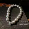 Las Flores Florecientes de la Bloguera: un Collar de Perlas de Múltiples Hilos Auténtico con Anillo de Abalorio de Concha de Nácar Negro y Diamantes Brillantes de Fénix y Colmena