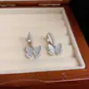 Moda francesa dulce combinable con todo hebilla de oreja de concha mariposa perla para mujer exquisita ligera de lujo temperamento pendiente de alta gama venta al por mayor