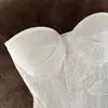 Elegante top de renda patchwork com detalhe de laço, cintura ajustada e efeito emagrecedor, tornando-o uma peça versátil