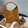 Nova bolsa de couro legítimo estilo balde da Song, um estilo retrô transfronteiriço com camurça e couro bovino de grão superior, projetada para ser usada tanto na mão quanto na transversal, para mulheres