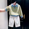 Ropa infantil estilo coreano 2026 colección otoño e invierno nueva: Suéter de punto con cuello tipo polo a rayas de contraste azul y amarillo y pantalones casuales blancos para niños