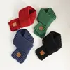 Bufanda de punto cálida y gruesa de estilo coreano para invierno para niños y niñas, protector de cuello infantil, a prueba de viento, color liso con etiqueta de cuero, venta al por mayor